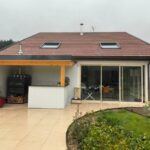 Maison avec extension véranda et abris en terrasse.